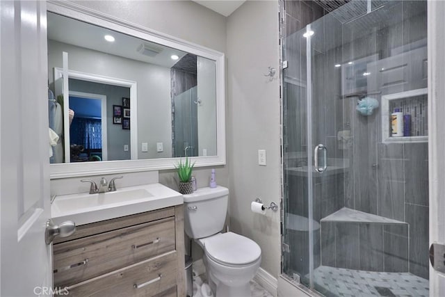 bathroom featuring visible vents, vanity, a shower stall, and toilet