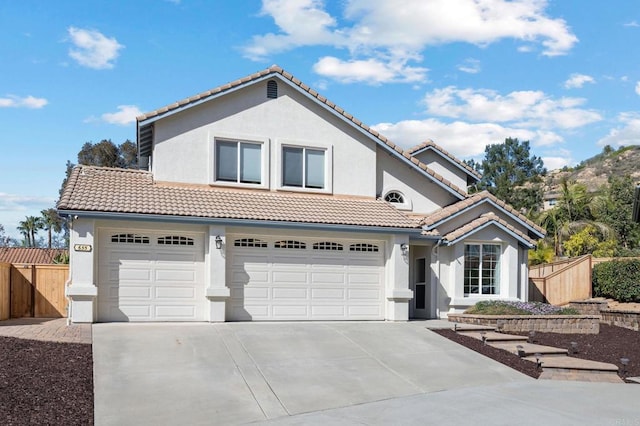 view of front of house featuring stucco siding, driveway, and fence