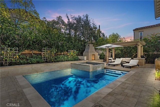 view of pool featuring an outdoor living space with a fireplace and a patio