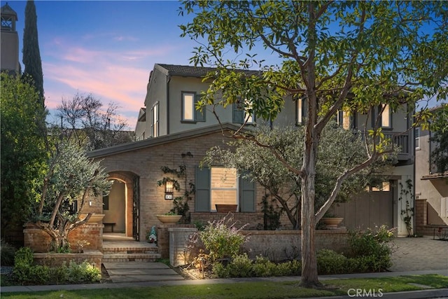 view of front facade featuring brick siding and stucco siding