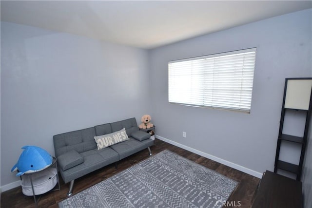 living area with baseboards and wood finished floors