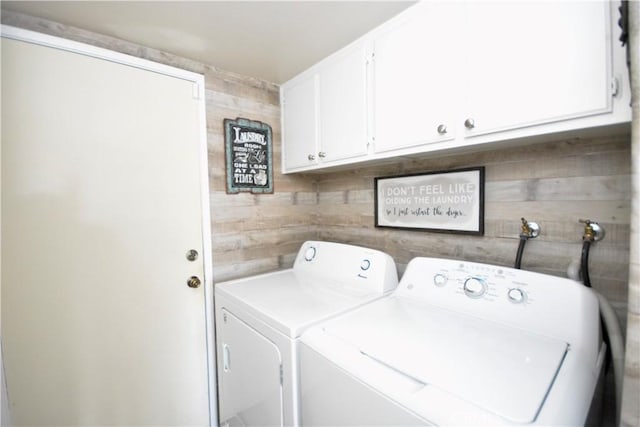 clothes washing area featuring cabinet space and washer and dryer