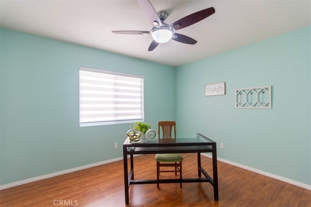 office space with a ceiling fan, baseboards, and wood finished floors