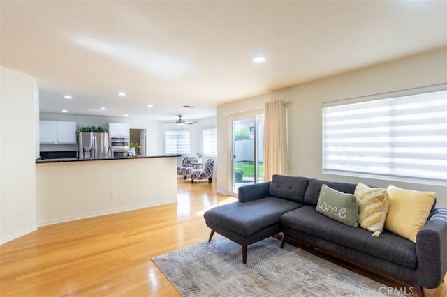 living room with light wood finished floors, recessed lighting, and baseboards