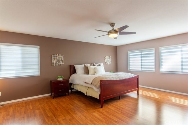 bedroom featuring light wood-style floors, baseboards, and a ceiling fan