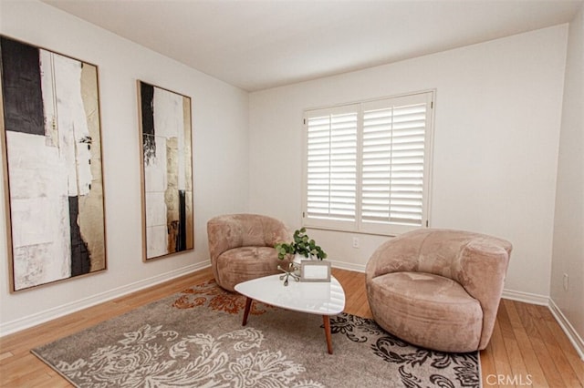 living area featuring baseboards and wood finished floors