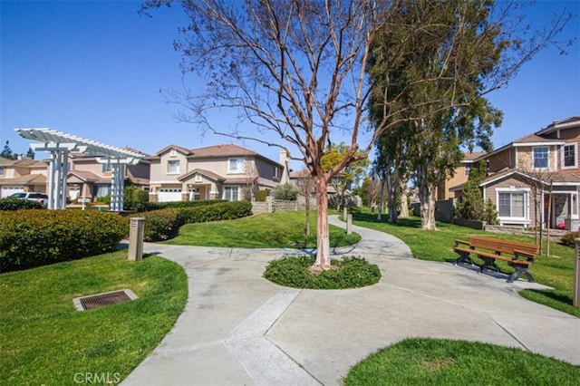 view of home's community featuring a lawn, a residential view, and a pergola