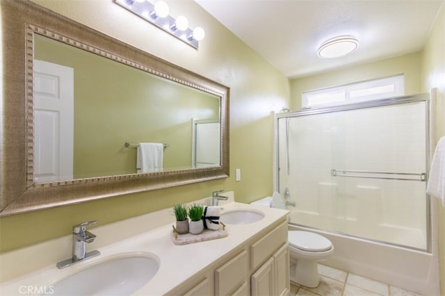 full bath featuring enclosed tub / shower combo, a sink, toilet, and tile patterned floors