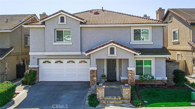 view of front of home featuring a tile roof, stucco siding, an attached garage, stone siding, and driveway