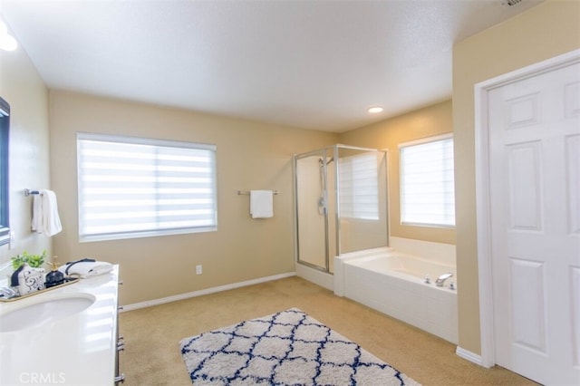 bathroom with a garden tub, a shower stall, baseboards, and vanity