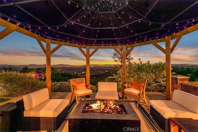 patio terrace at dusk with a gazebo and an outdoor living space with a fire pit