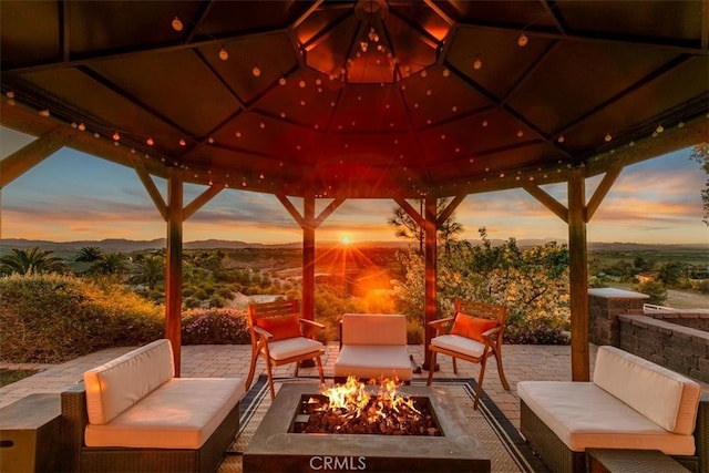 view of patio / terrace featuring an outdoor living space with a fire pit and a mountain view