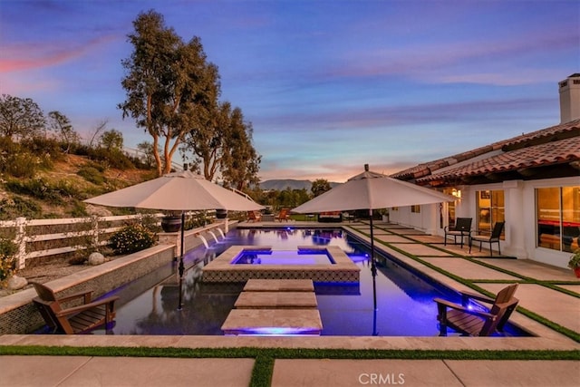 pool at dusk with a patio and a fenced in pool