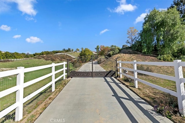 view of gate with a rural view and fence