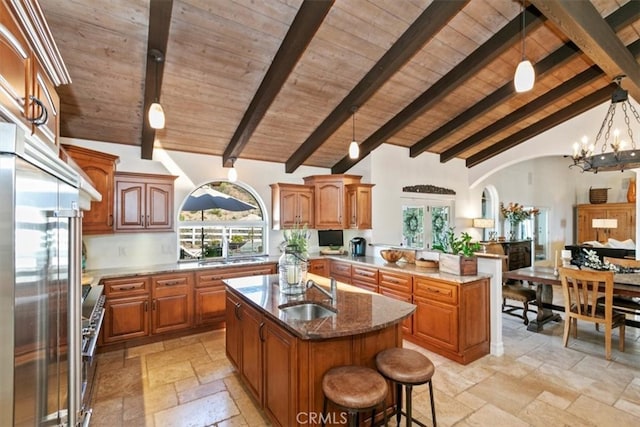 kitchen with wooden ceiling, stone tile floors, and a sink