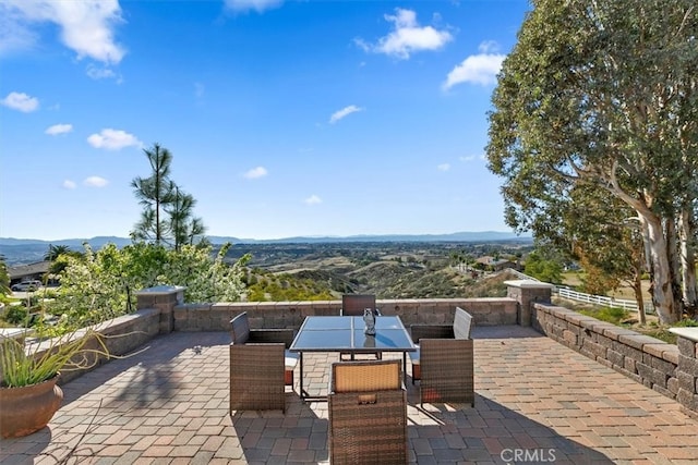 view of patio / terrace with a mountain view and outdoor dining space