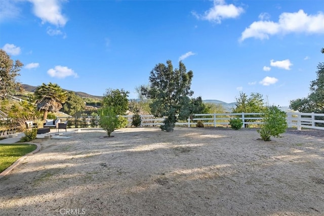 view of yard featuring fence and a mountain view