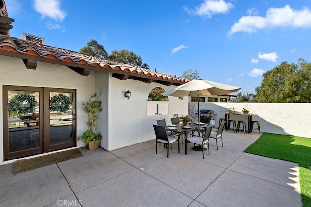 view of patio with outdoor dining area, area for grilling, and fence