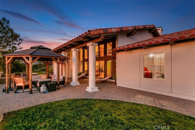 exterior space featuring a patio area, a tiled roof, outdoor lounge area, and a gazebo