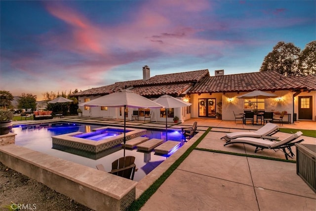 outdoor pool with an in ground hot tub, a patio, and an outdoor living space