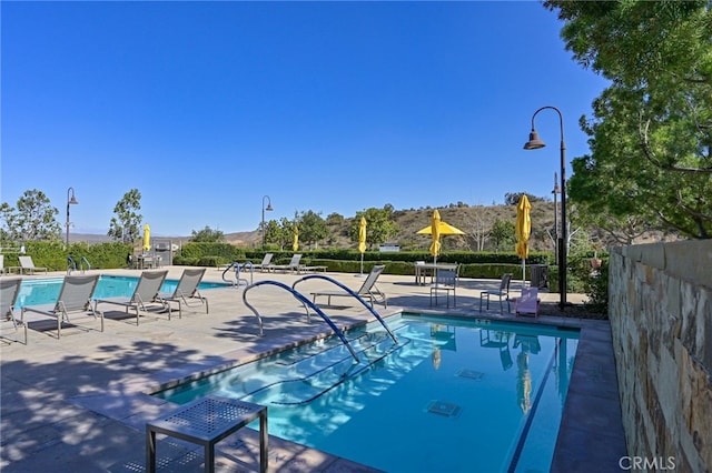 pool with a patio area and fence