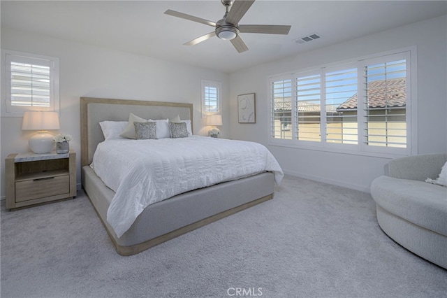 carpeted bedroom with a ceiling fan, visible vents, and baseboards