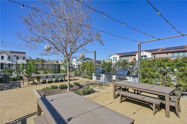 view of patio with exterior kitchen, a residential view, outdoor dining area, and fence