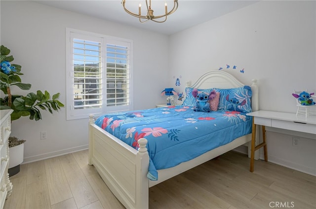 bedroom featuring light wood-style flooring, baseboards, and an inviting chandelier