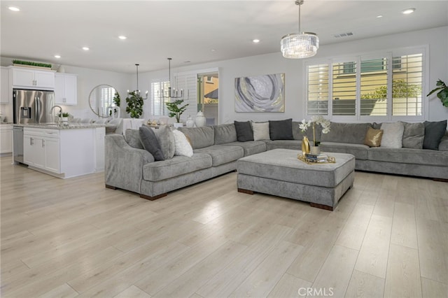 living room featuring a healthy amount of sunlight, recessed lighting, visible vents, and light wood-style floors