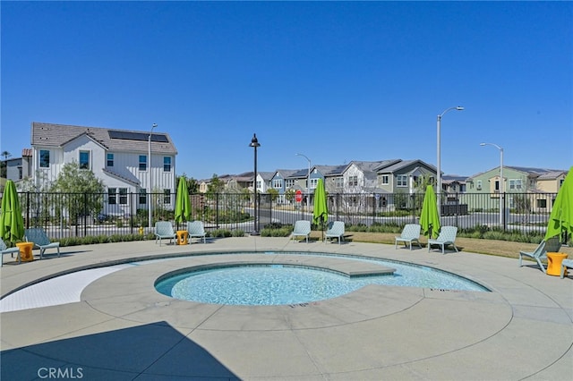 view of pool with a residential view, fence, and a patio