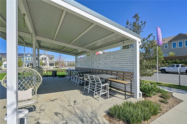 view of property's community with outdoor dining space and a patio area