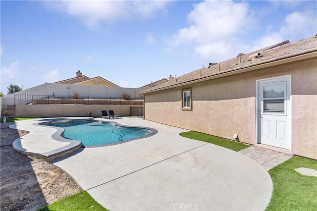 view of swimming pool featuring a pool with connected hot tub, a patio area, and a fenced backyard