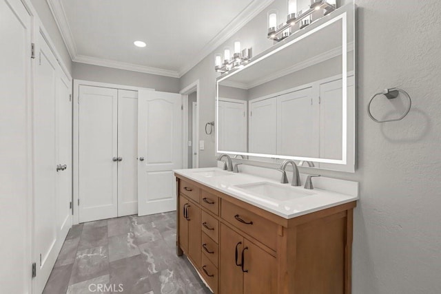 bathroom featuring ornamental molding, a textured wall, a sink, and double vanity