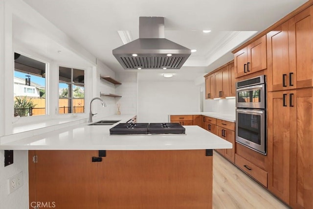 kitchen featuring open shelves, appliances with stainless steel finishes, a sink, island range hood, and a peninsula