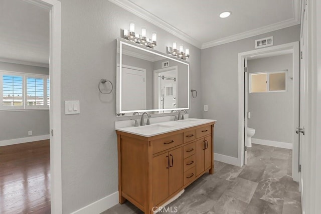 bathroom with toilet, a sink, visible vents, and crown molding