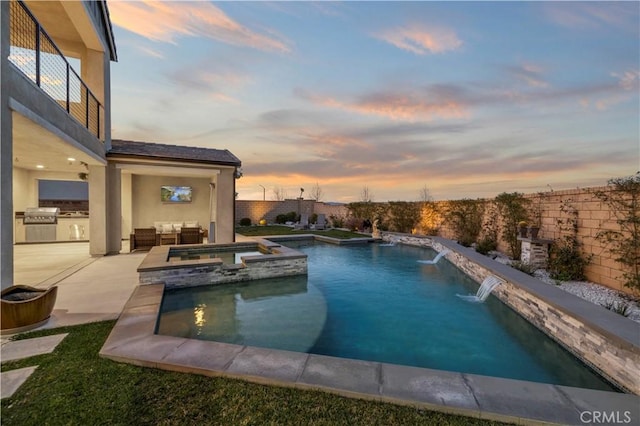 view of swimming pool with a patio area, an outdoor kitchen, a grill, and a pool with connected hot tub