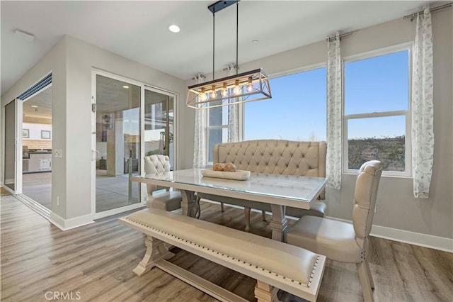 dining space with baseboards, wood finished floors, and recessed lighting