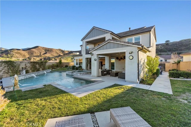 rear view of property featuring a fenced backyard, an outdoor living space, board and batten siding, and a yard