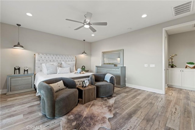 bedroom with recessed lighting, visible vents, baseboards, and wood finished floors