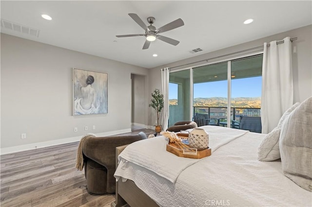 bedroom with access to outside, visible vents, baseboards, and wood finished floors