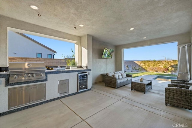 view of patio / terrace featuring exterior kitchen, wine cooler, outdoor lounge area, and a grill