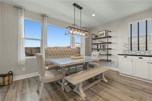 dining room with plenty of natural light, baseboards, and light wood-style flooring