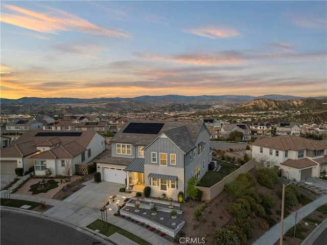 aerial view at dusk featuring a residential view and a mountain view