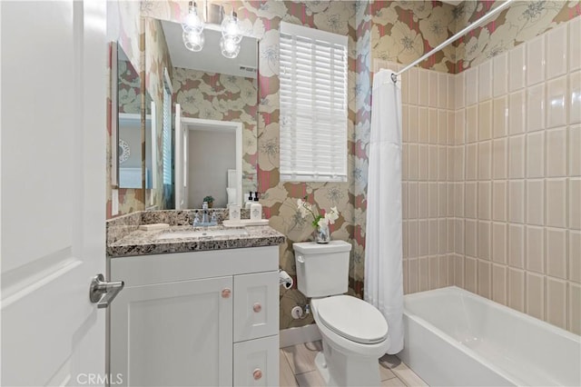 bathroom featuring toilet, vanity, baseboards, shower / tub combo with curtain, and wallpapered walls