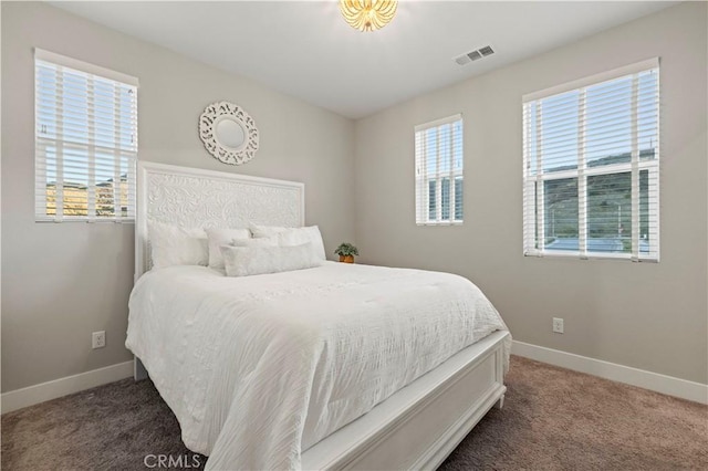 carpeted bedroom with visible vents and baseboards