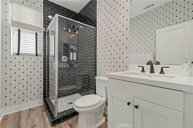 full bathroom with wallpapered walls, wood finished floors, and a stall shower