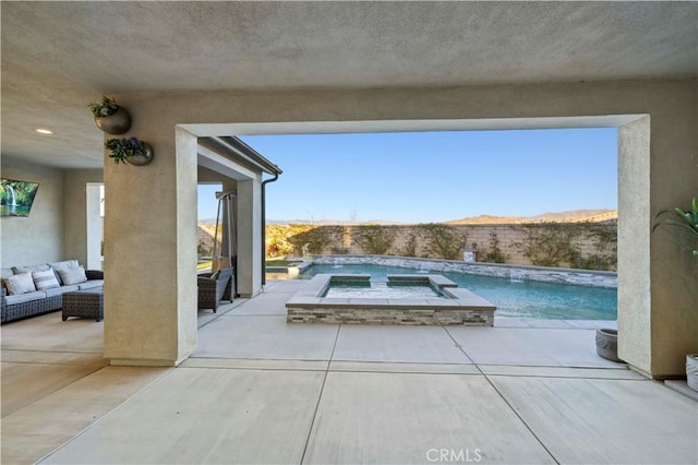 outdoor pool with an in ground hot tub, outdoor lounge area, a patio area, and a mountain view