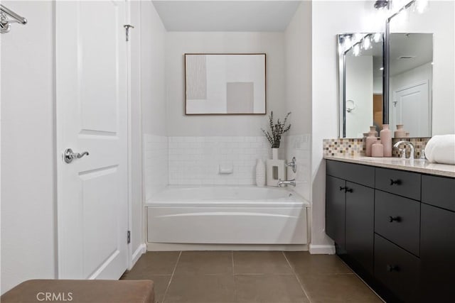 bathroom featuring tile patterned flooring, a garden tub, vanity, and decorative backsplash