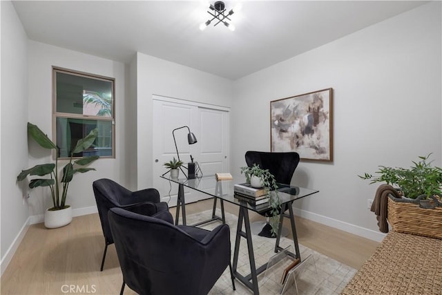 office area with baseboards and light wood finished floors