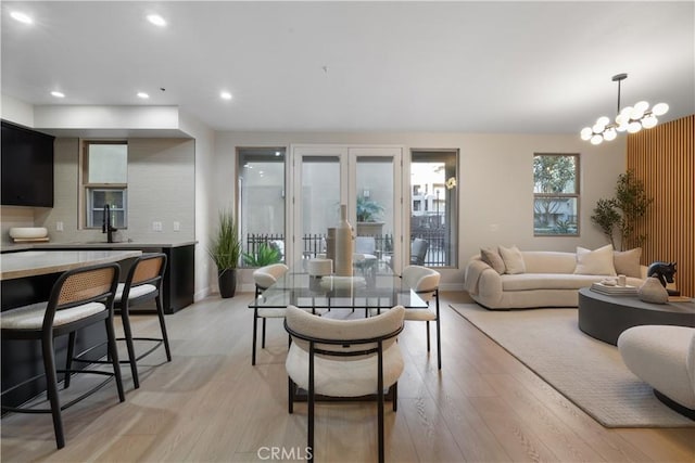 living room with light wood-style floors, recessed lighting, a chandelier, and baseboards